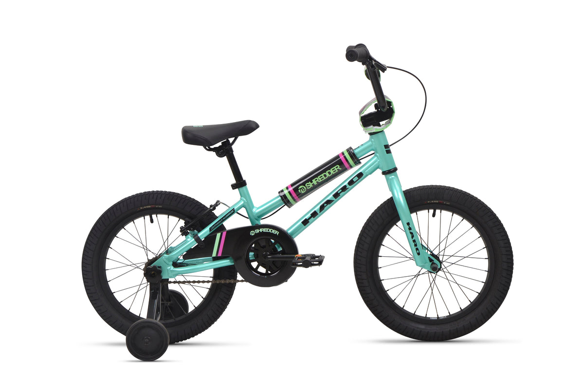 A Shredder 16 ST teal girls bike with training wheels, black seat, low top tube, and black tires is shown side view on white background.